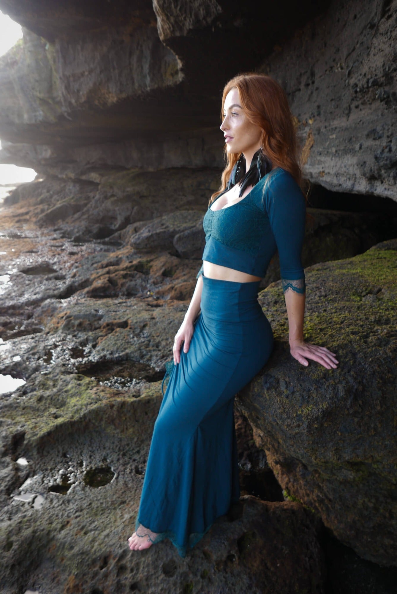 Mermaid lace -skirt and lace crop top in dark teal combined with black feather earrings.