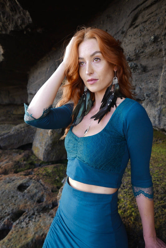 Lace crop top with mermaid lace skirt, combined with black feather earrings.