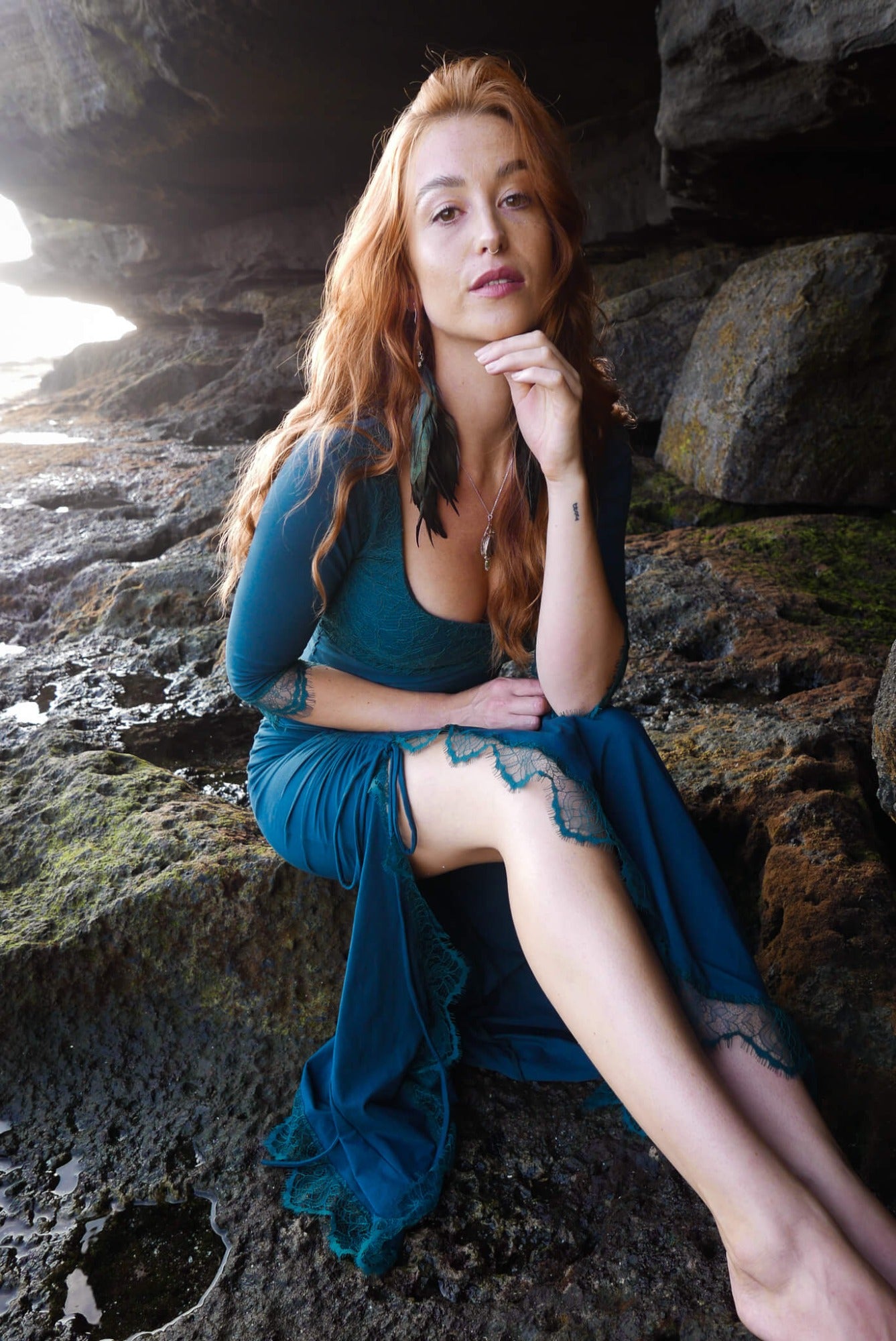 Mermaid lace -skirt and lace crop top in dark teal combined with black feather earrings.