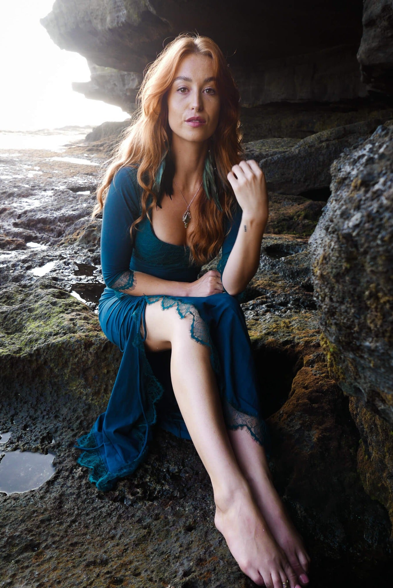Mermaid lace -skirt and lace crop top in dark teal combined with black feather earrings.