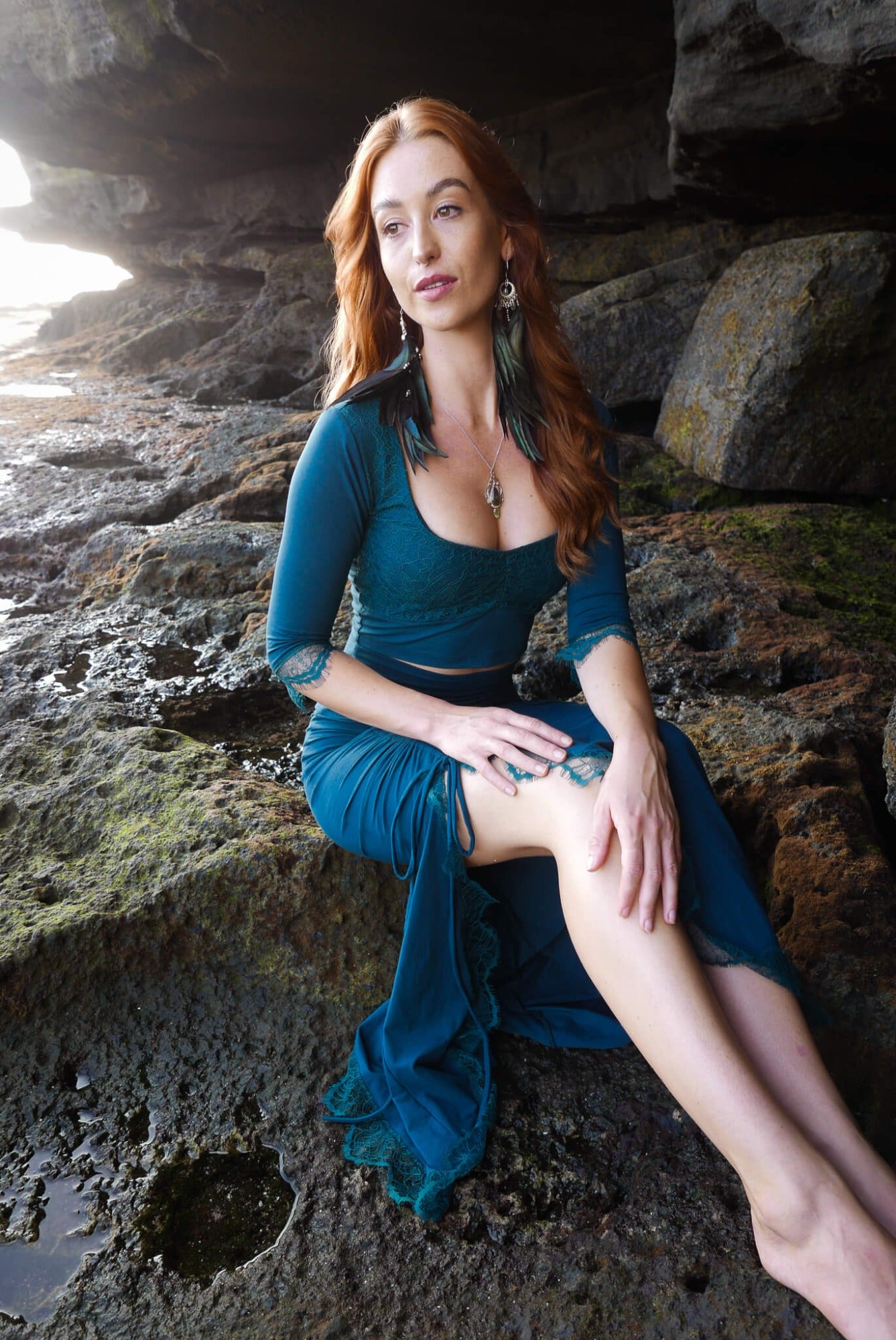 Mermaid lace -skirt and lace crop top in dark teal combined with black feather earrings.
