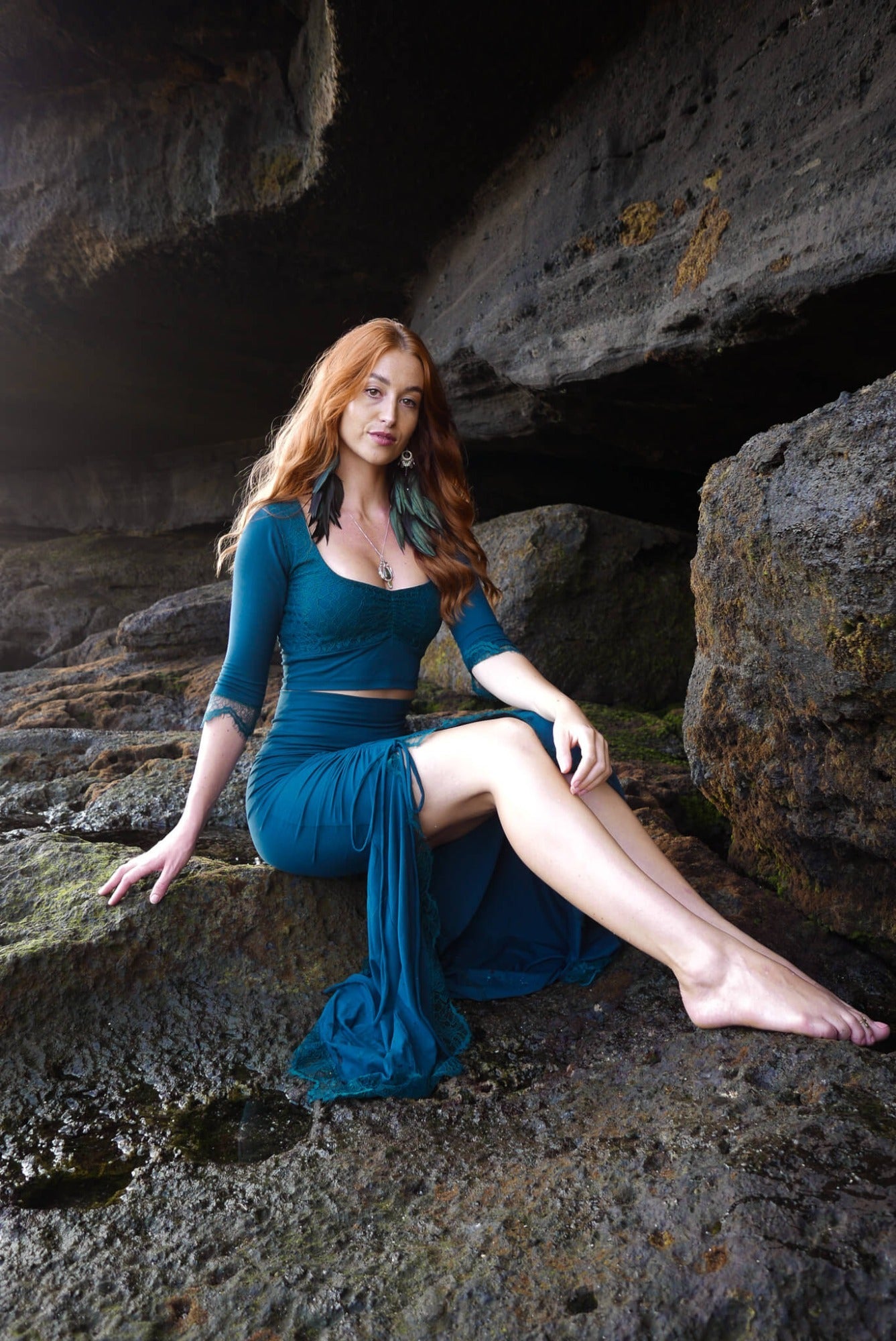 Mermaid lace -skirt and lace crop top in dark teal combined with black feather earrings.