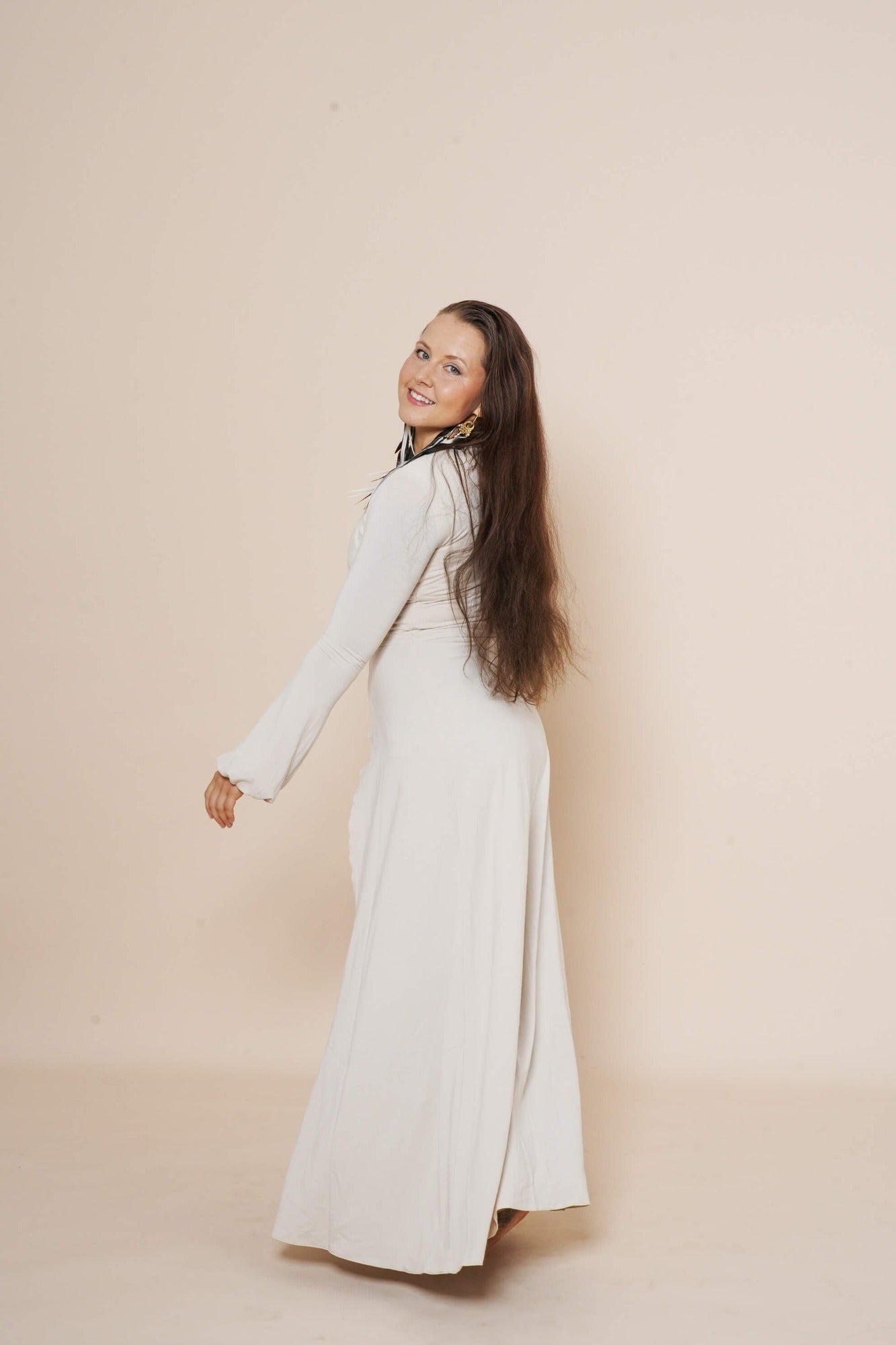 Long puffy sleeve vest in color winter white, combined with flair pants and halter top in color taupe.