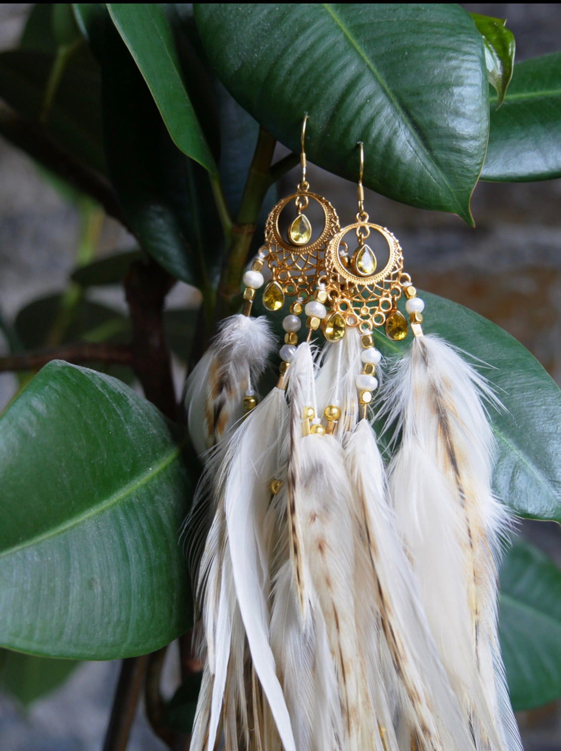 Closeup goddess feather earring adornments with citrine crystals
