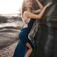 Beautiful dress with open back, side cuts and delicate strap details crossing the back in color dark teal.