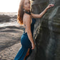 Beautiful dress with open back, side cuts and delicate strap details crossing the back in color dark teal.