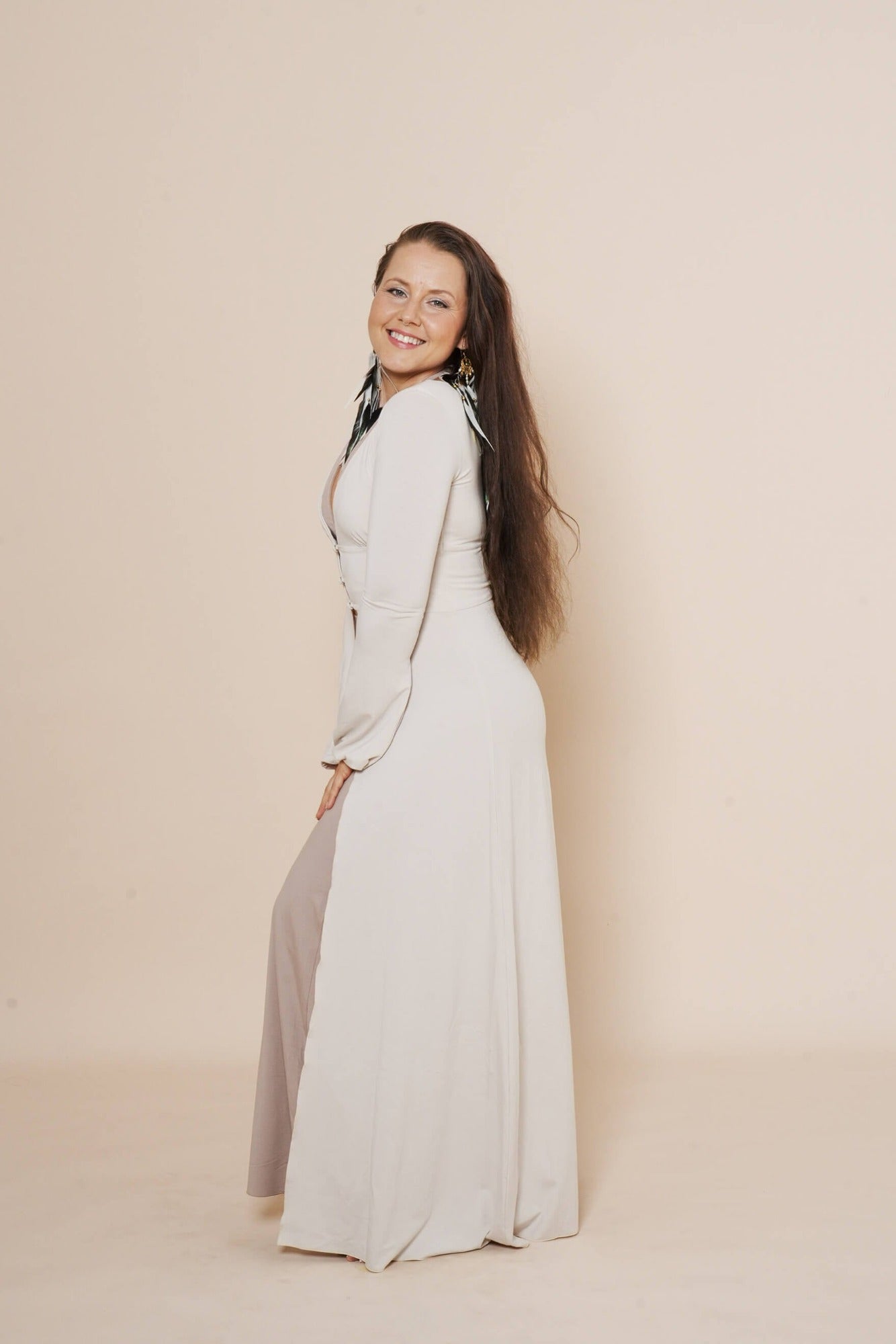 Long puffy sleeve vest in color winter white, combined with flair pants and halter top in color taupe.
