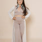 Long puffy sleeve vest in color winter white, combined with flair pants and halter top in color taupe, combined with Green topaz feather earrings.