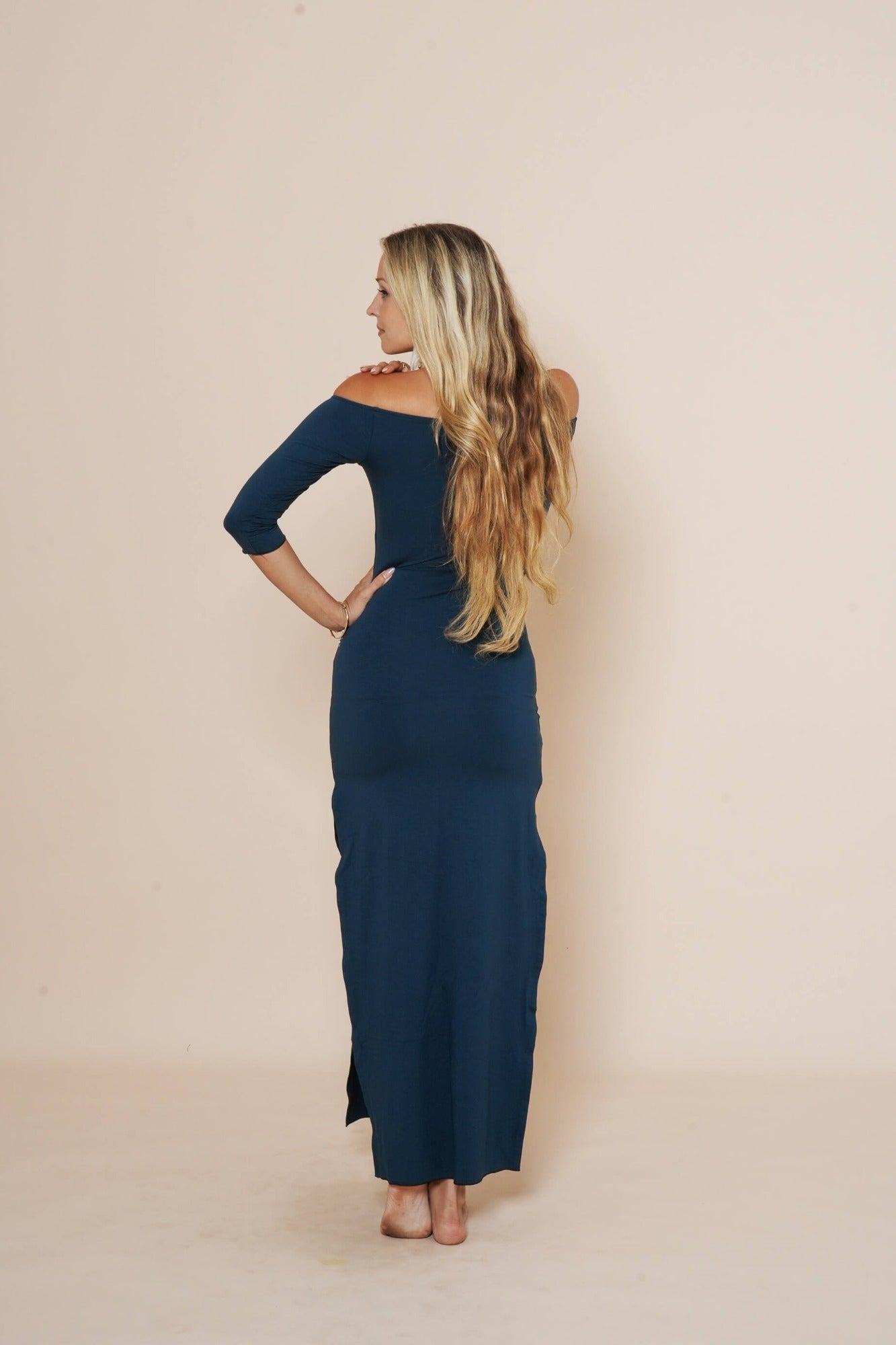 Off shoulder long dress with side cuts and 3/4 sleeves in color dark teal.