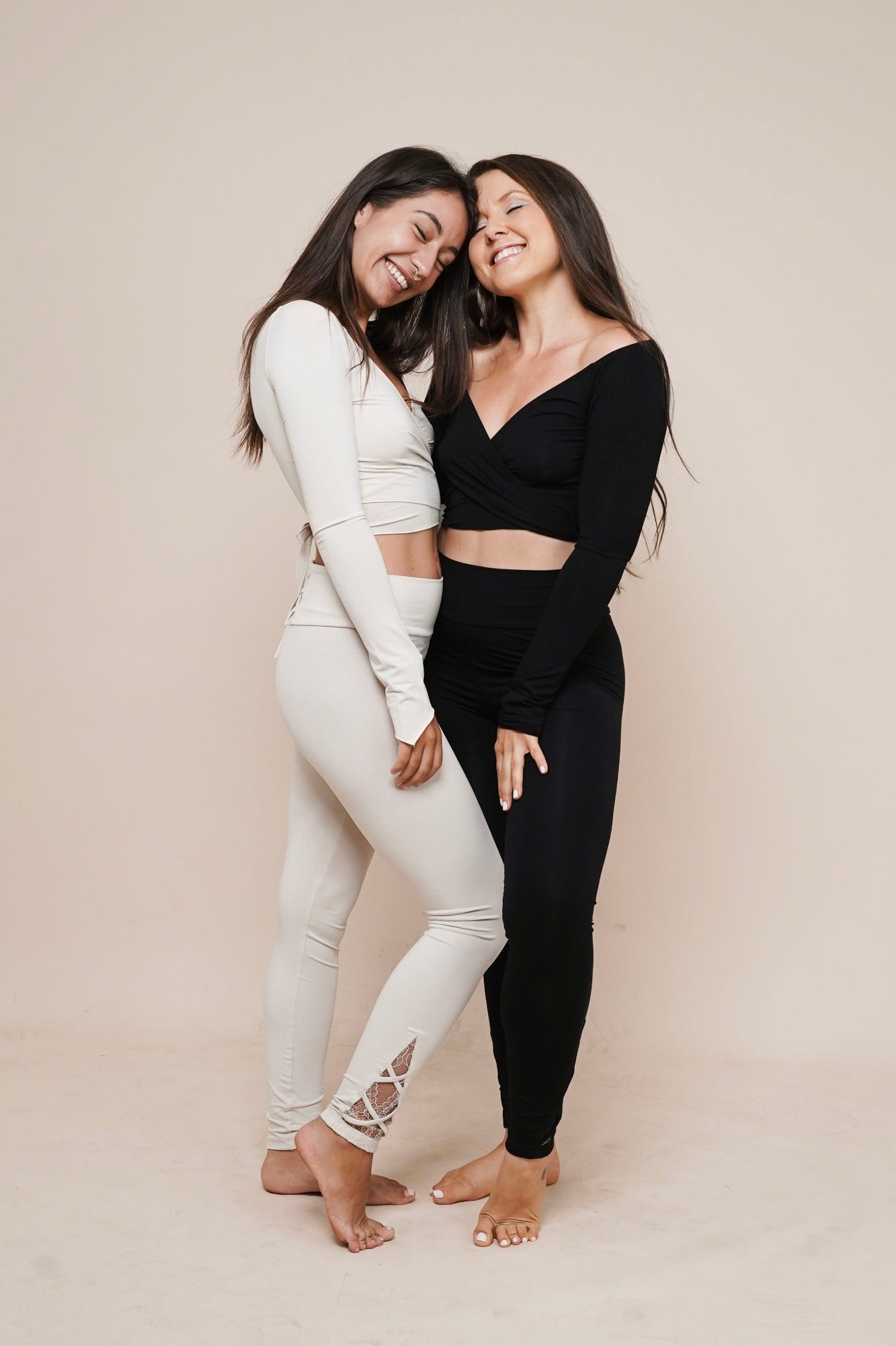 Charm off-shoulder wrap shirt winter white and black styled with leggings on two women smiling