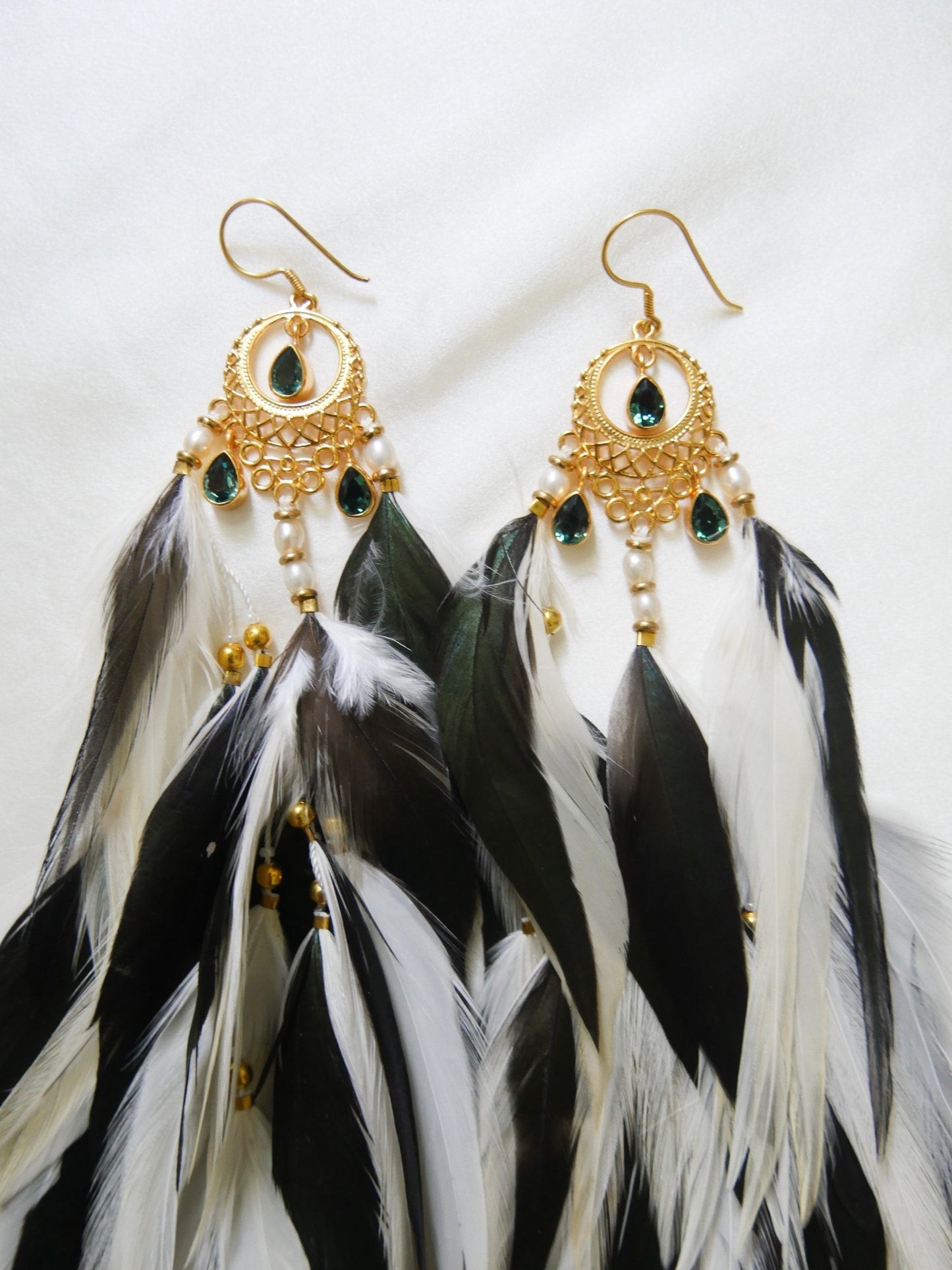 Bohemian Goddess long feather earrings with white and emerald green feathers, green quartz crystals and a gold plated brass moon chandelier.