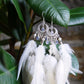 White rooster feather earrings with moonstone stones and silver accents — feminine essence jewelry close up